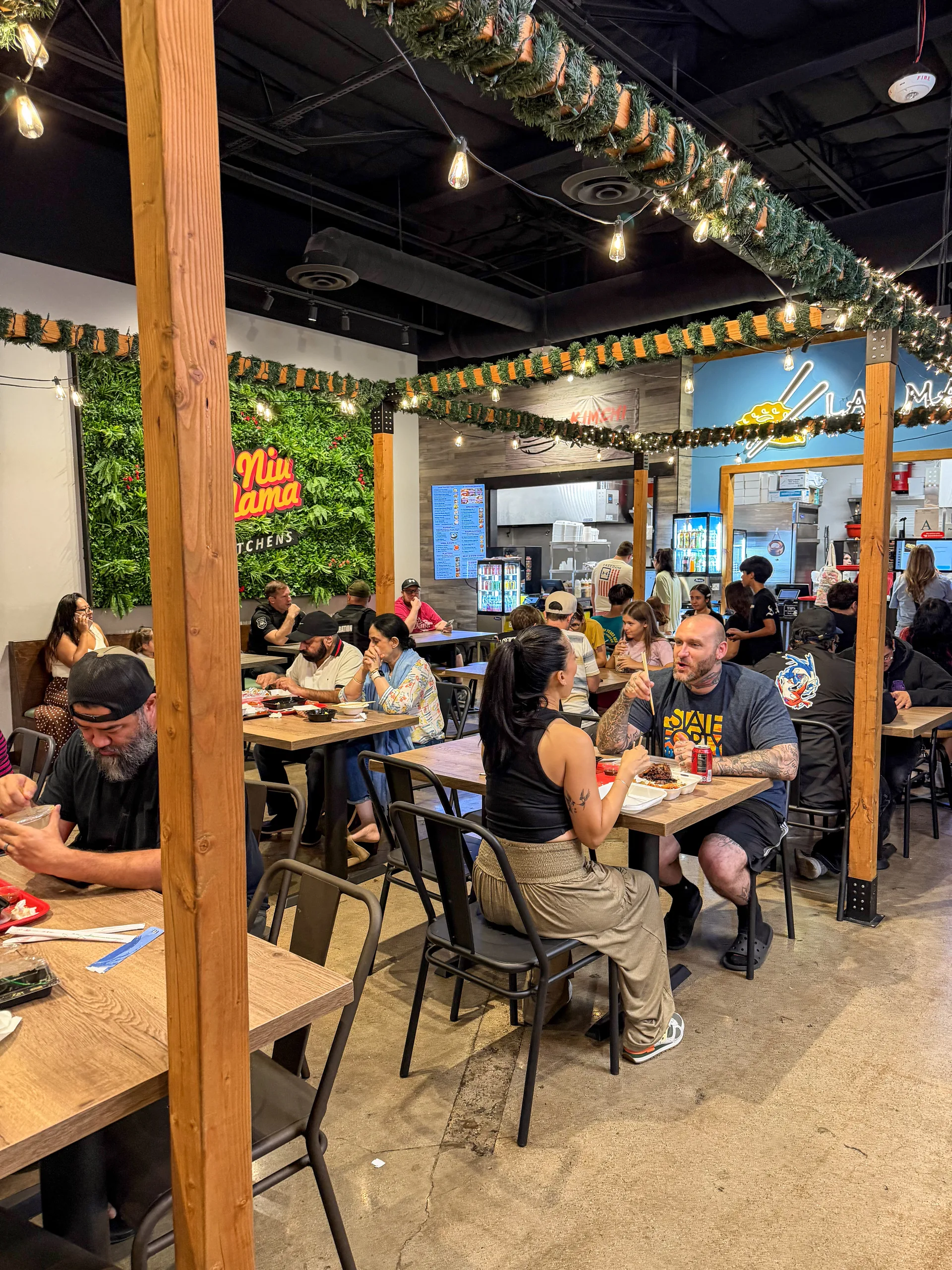 A busy evening at Niu Mama Kitchens, with the Lao Ma and Kimchi Xpress counters behind full tables