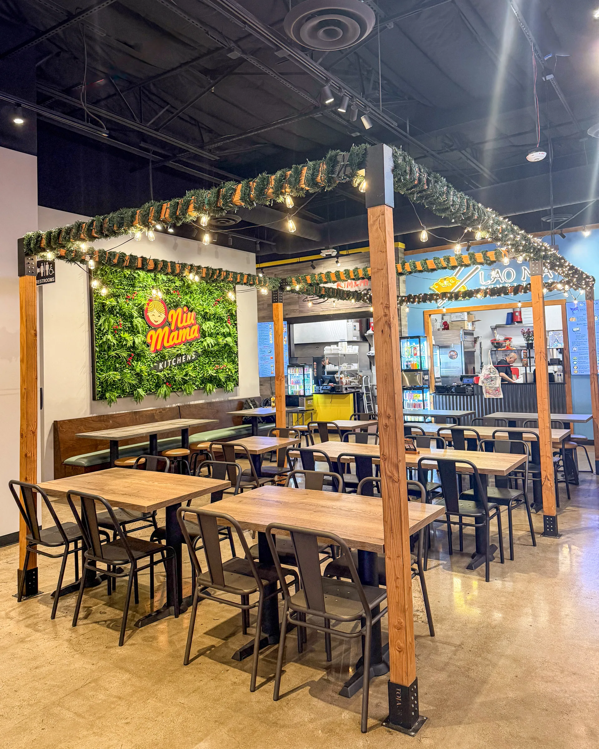 Communal tables and the Niu Mama Kitchens living wall, with the Lao Ma counter beyond